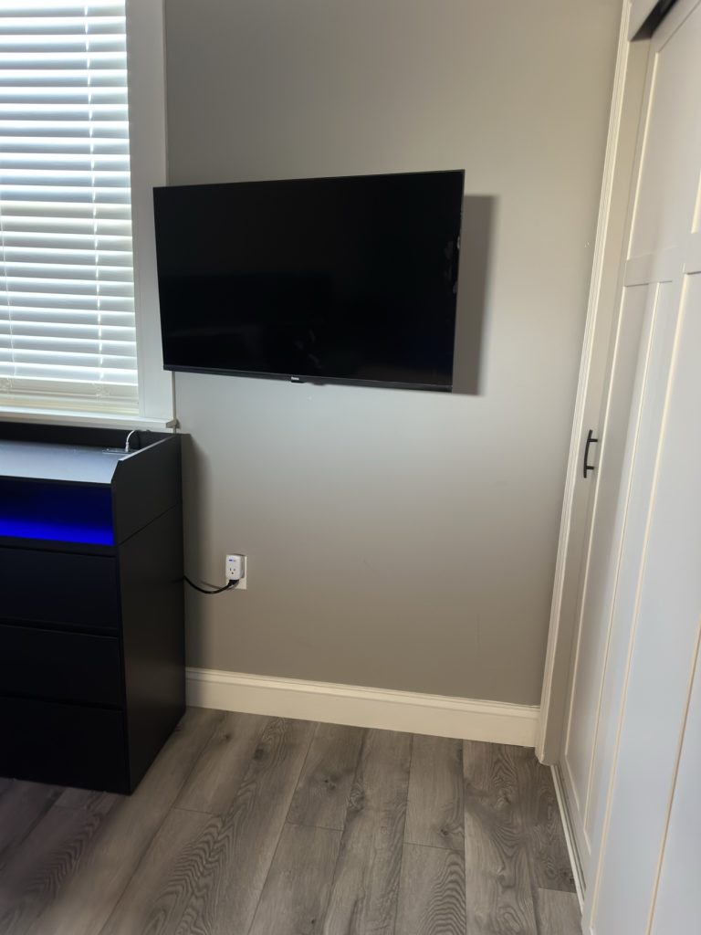 Tidy bedroom with wall-mounted TV