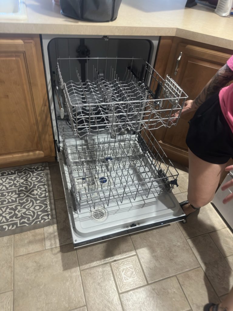 Empty dishwasher with racks pulled out after cleaning