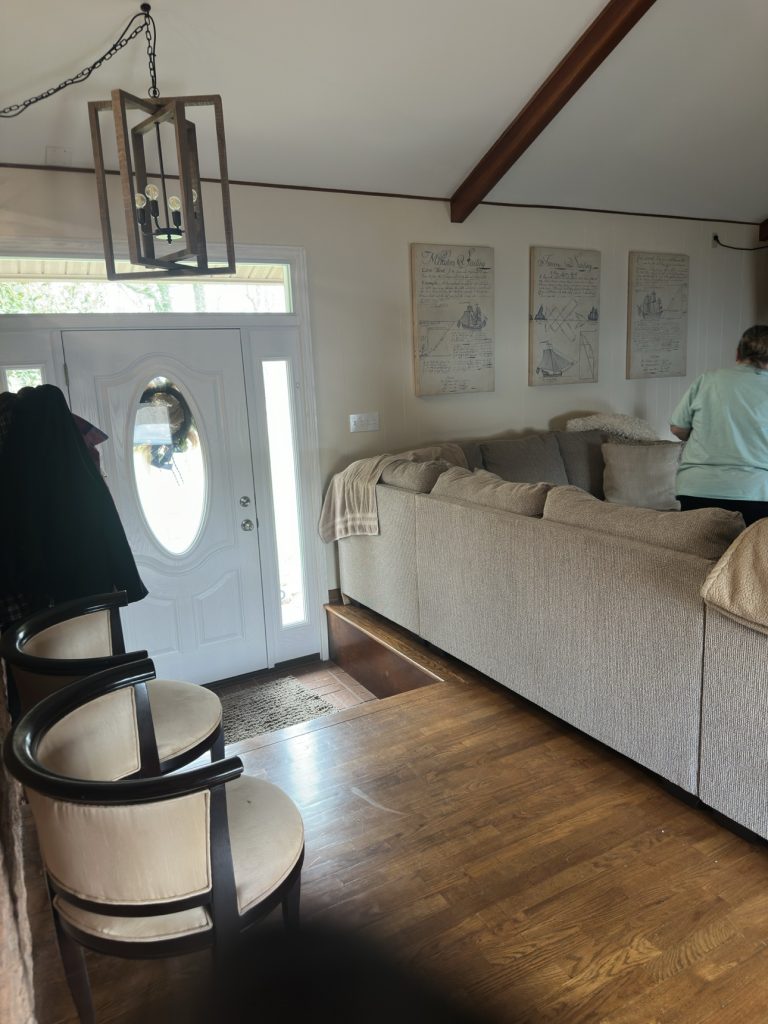 Clean entryway and living room with sofa after cleaning